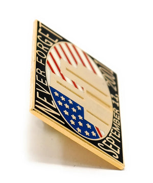 9-11 September 11, 2001 Collectible Commemorative Lapel Pin is designed with the tower skyline in front of red, white, and blue American flag details, with the words "Never Forget September 11, 2001" in gold letters. Made with a yellow gold jewelry-grade metal.